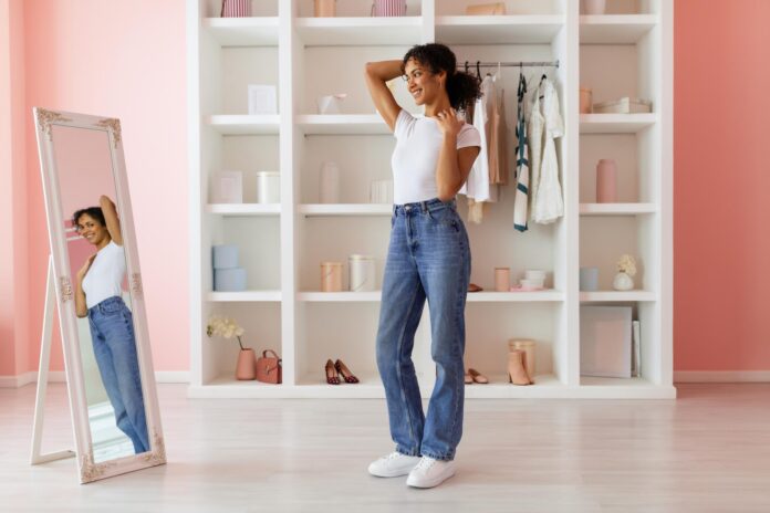 Confident latin woman posing in jeans admiring mirror image